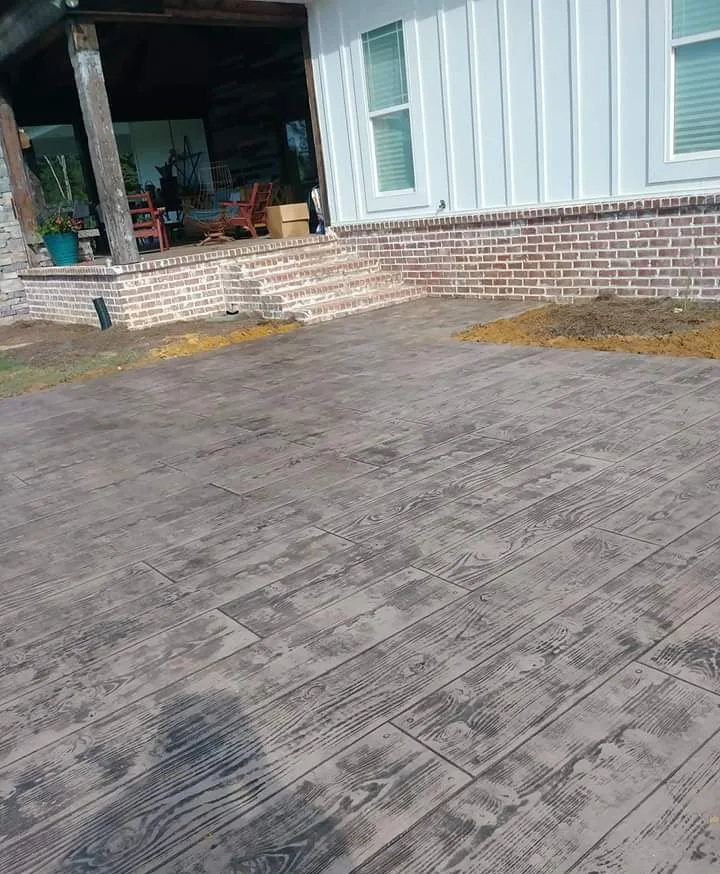 Wood-look stamped concrete porch outside a modern farmhouse